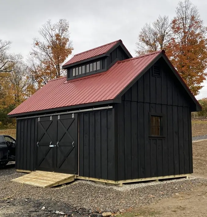 a sugar house built in Whiting Vermont with black siding, and a red metal roof